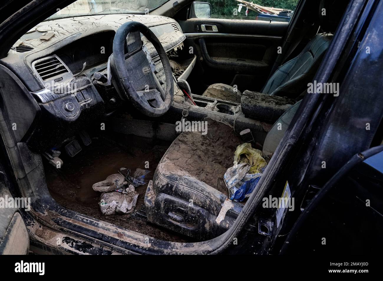 A car is filled with dry mud in the aftermath of massive flooding