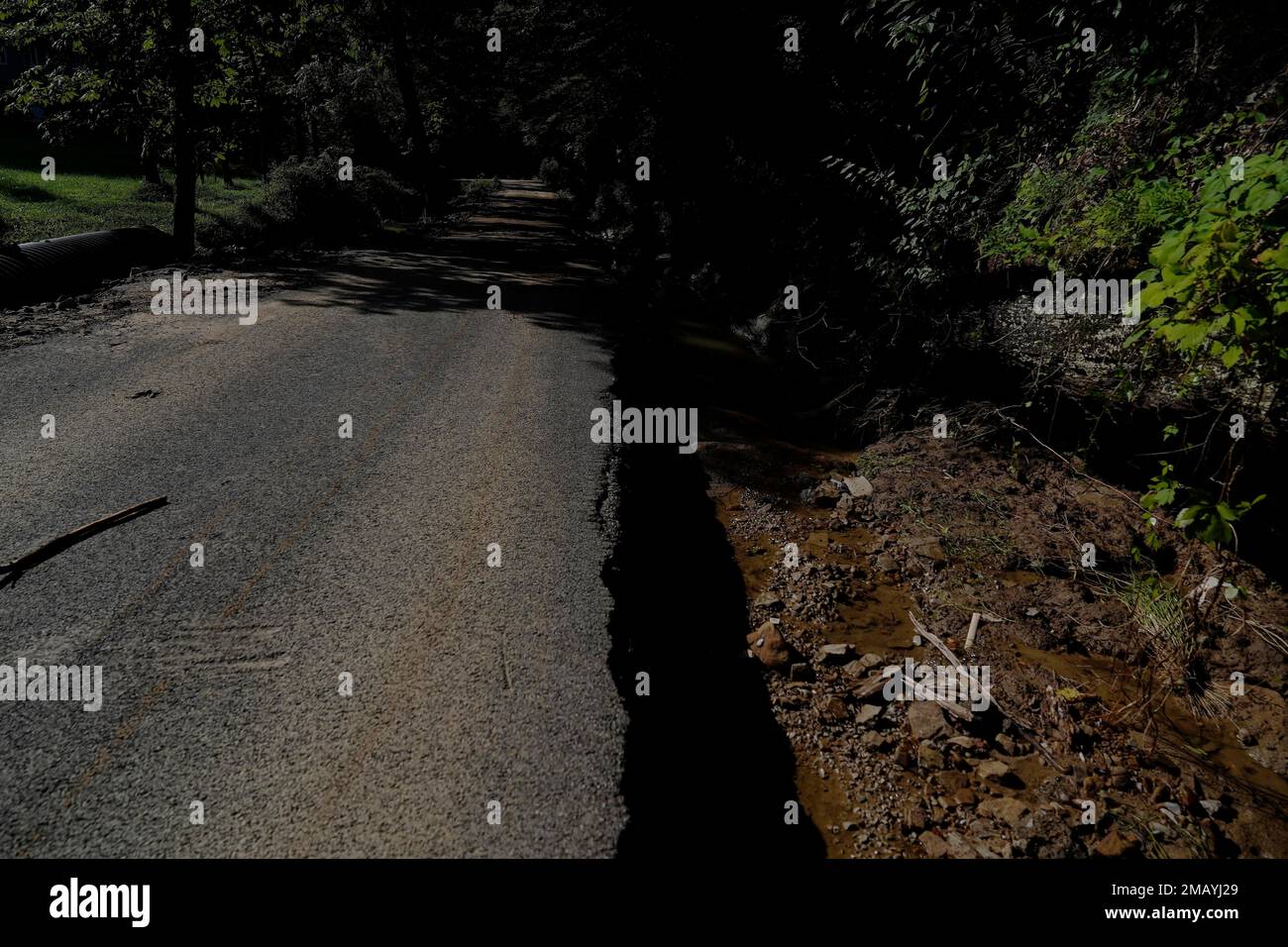 Pieces of a road broke away and left exposed ground and debris in the