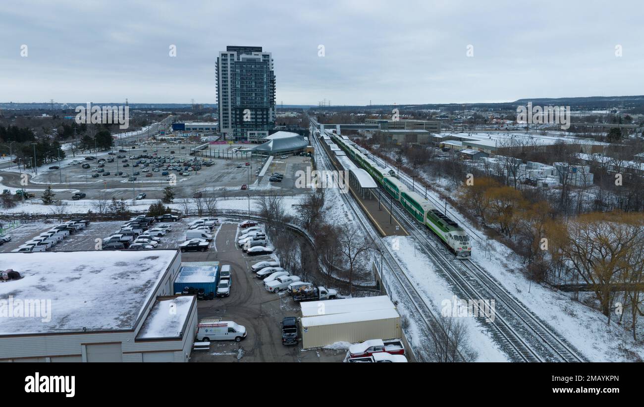An aerial photo of GO Train, GO Transit locomotive, while it sits stationary at a snow-covered Burlington train station in the winter. Stock Photo