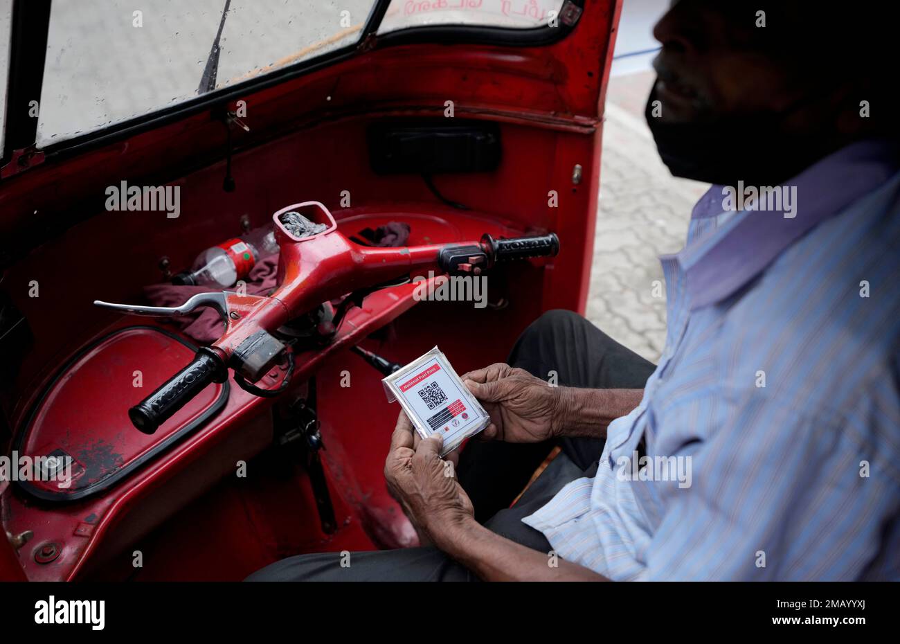 Qr Code On Rickshaw An auto rickshaw driver waits to buy fuel holding a QR code at a fuel ...