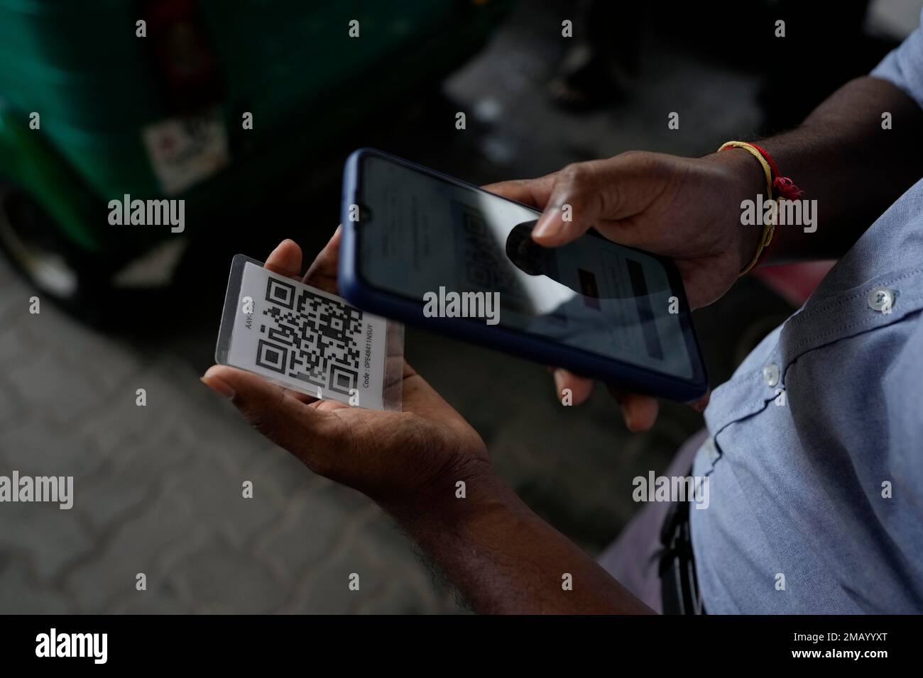 A worker scans a QR code before pumping gas to a vehicle at a fuel