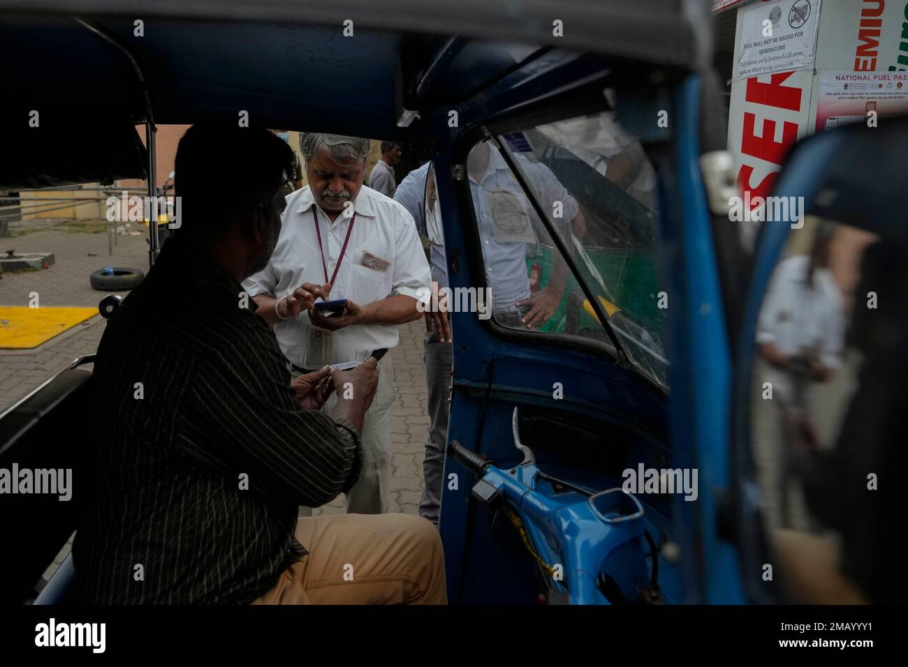 A worker scans a QR code before pumping gas to a vehicle at a fuel