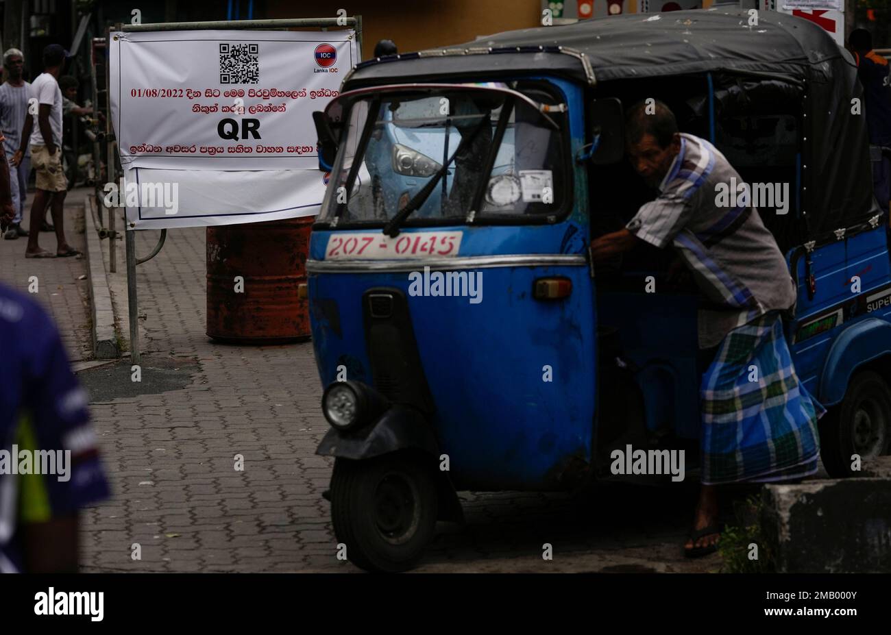 Qr Code On Rickshaw An auto rickshaw driver pushes his vehicle next to a banner that says ...