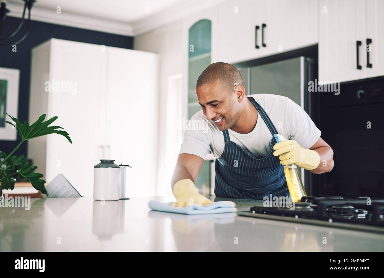 Wiping away all the dirty. a young man wiping a surface at home Stock Photo Alamy