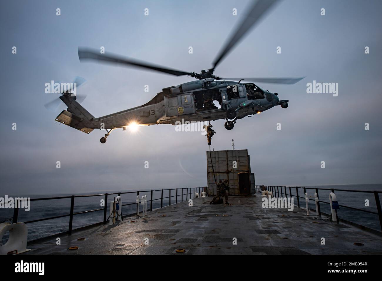 220608-N-LP924-1685 PACIFIC OCEAN (June 8, 2022) U.S. Coast Guardsmen from Maritime Safety Response Team West (MSRT-W) conduct helicopter visit, board, search and seizure (HVBSS) training alongside an MH-60S Sea Hawk, assigned to the “Black Knights” of Helicopter Sea Combat Squadron (HSC) 4, off the coast of San Diego. During Helicopter Sea Combat Weapons School Pacific (HSCWSP) quarterly exercise PHOENIX TRIDENT ASSAULT, MSRT-W and squadrons from Helicopter Sea Combat Wing Pacific (HSCWP) and Helicopter Maritime Strike Wing Pacific (HSMWP) conducted HVBSS to board and secure vessels that were Stock Photo