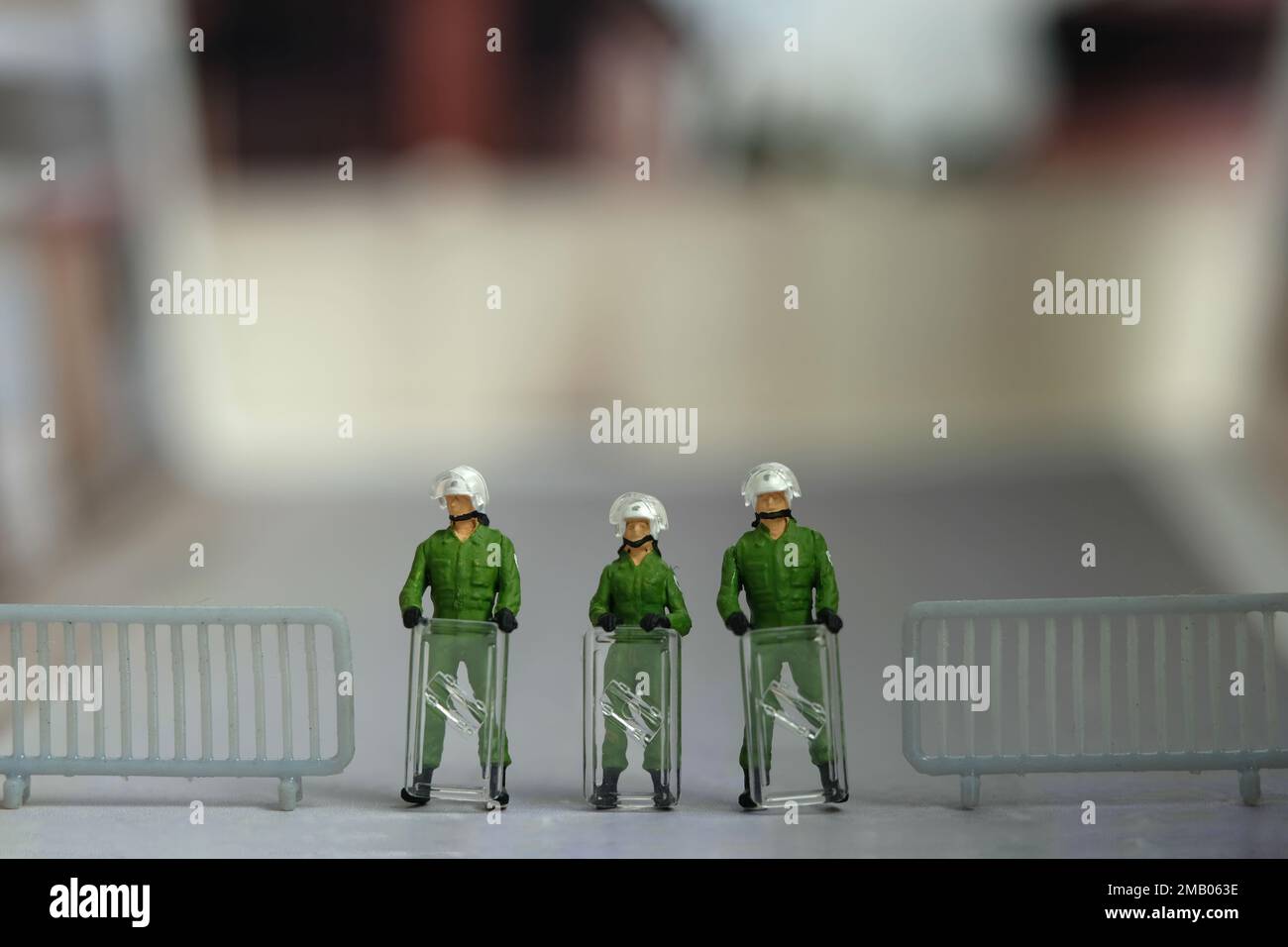 Miniature people toy figure photography. A military anti riot armored army standing on barricades, securing the road way. Image photo Stock Photo