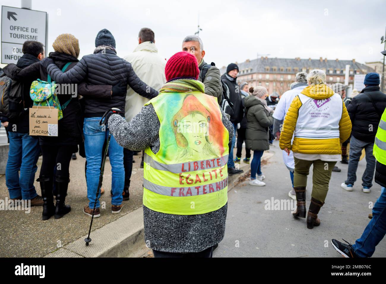 Strasbourg, France - Jan 19, 2023: Liberte Egalite Fraternite on woman yellow vest at protest against the French government's planned pension reform to push the retirement age from 62 to 64 unions have called for mass social action Stock Photo