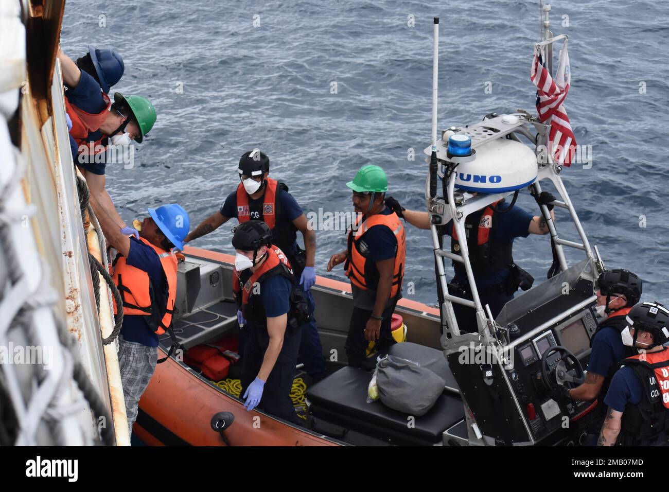 The crew of U.S. Coast Guard Cutter Steadfast helps two survivors who were lost at sea for 23 days come aboard the cutter June 8, 2022. The imperiled mariners stated that they were fishermen who had been adrift for 23 days after their vessel was beset by weather. Stock Photo