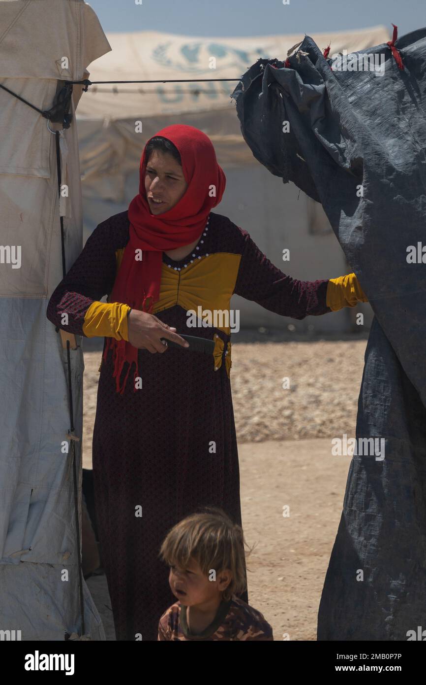 Syria – A woman and child watch as members with a Combined Special Operations Joint Task Force – Levant’s Civil Affairs Team visit the internally displaced persons camp in northeast Syria, June 9, 2022. Stock Photo