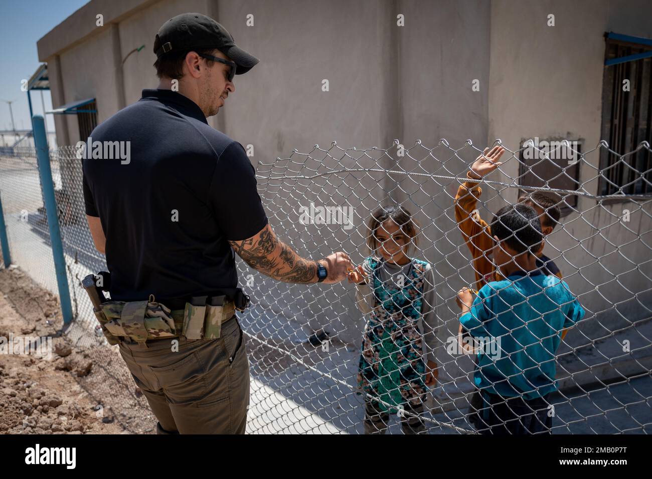 Syria – A member of a Combined Special Operations Joint Task Force – Levant’s Civil Affairs Team, passes out candy to children during a visit to the internally displaced persons camp near Areesha in the Hasakah region of Syria, June 9, 2022. Stock Photo