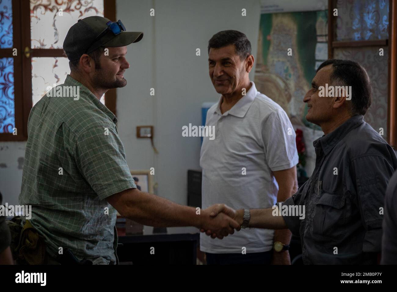 Northeast Syria – Combined Special Operations Joint Task Force – Levant Civil Affairs Team (CAT) Team Leader, shakes hands with administrators of the internally displaced persons camp in Areesha, Syria following a discussion of the situation in the camp during a key leader engagement and site survey, June 9, 2022. Stock Photo