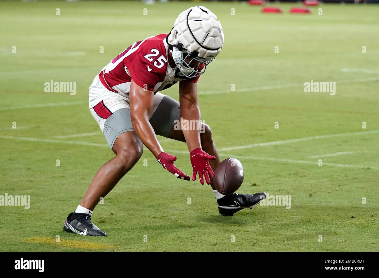 Arizona Cardinals linebacker Zaven Collins scoops up the ball as he