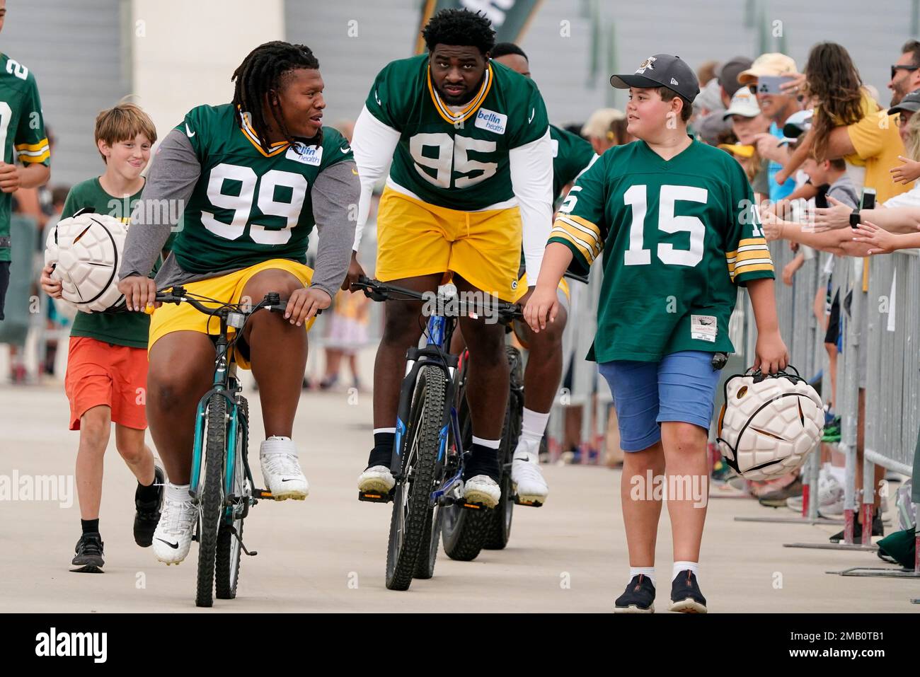 Green Bay Packers' Devonte Wyatt and Jonathan Ford (99) ride bikes