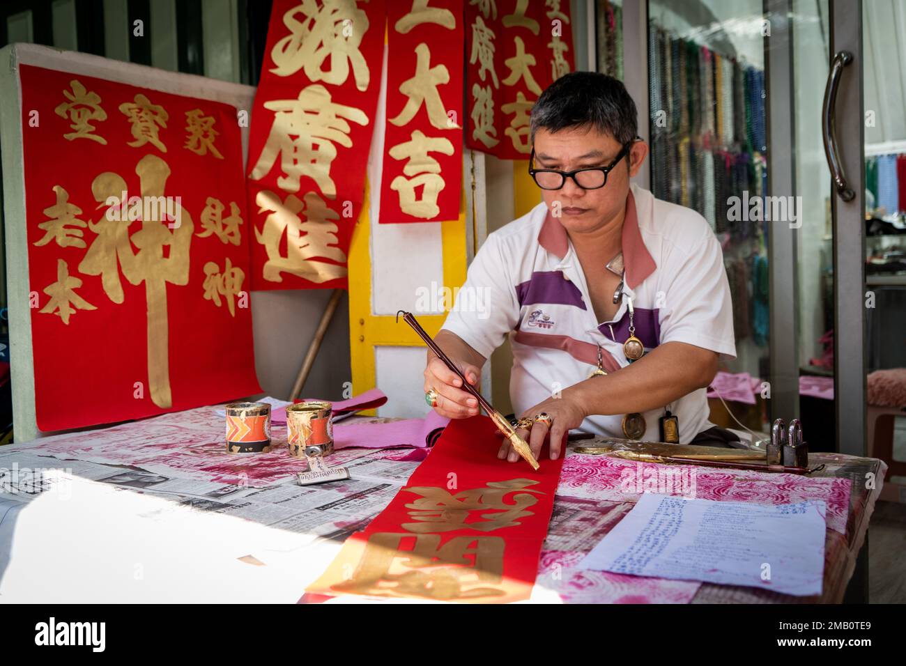 An artist paints Chinese lettering onto greeting cards. Lunar New Year 2023 (The Year of the Rabbit), also known as the Chinese New Year and the Spring Festival, begins as Chinese tourists return to Thailand for the first time since the zero-covid lockdown began in Mainland China 3 years ago. The Thai government expects at least five million Chinese tourists will visit the Kingdom this year. Stock Photo