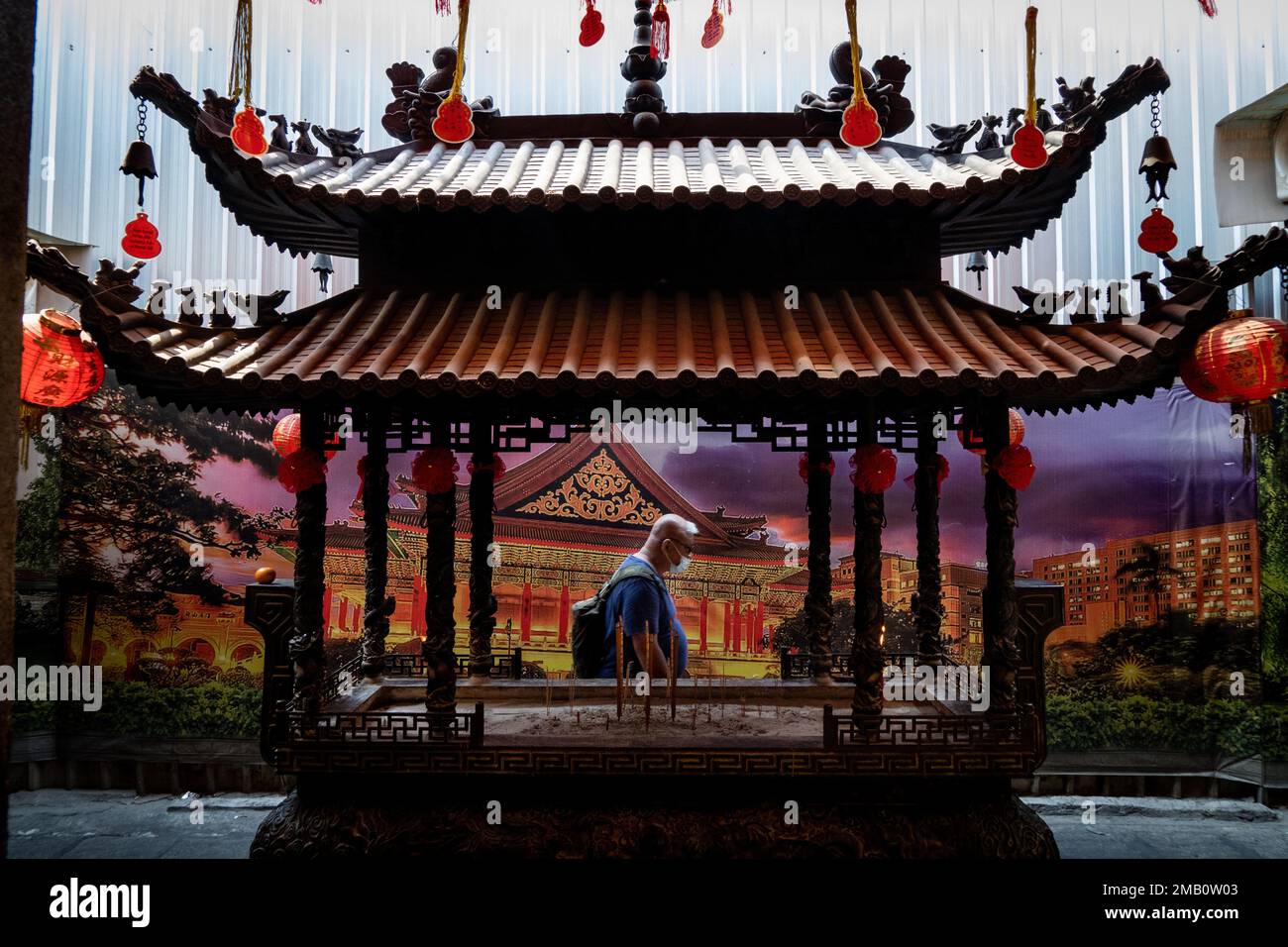 A tourist walks through a model of a shrine used for prayer at a temple ...