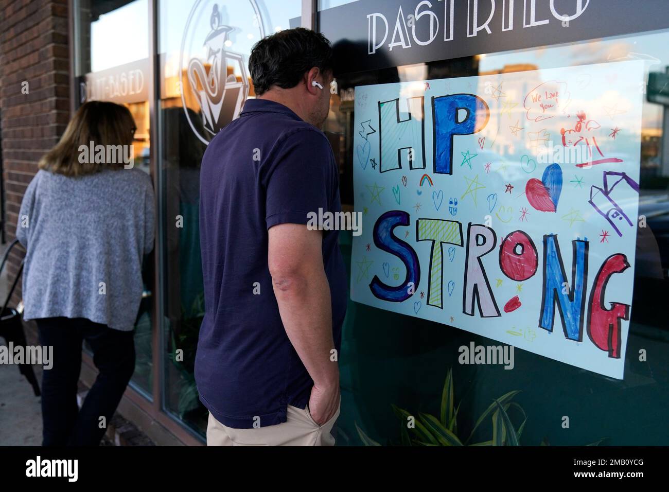 A sign about HP strong is displayed as people look through a window of Madame Zuzus, Wednesday, July 27, 2022, in Highland Park, Ill