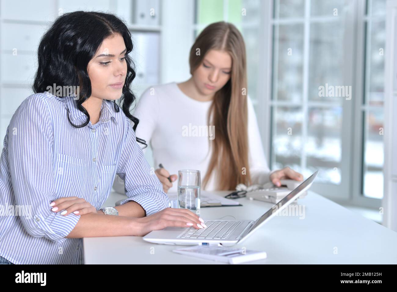 Young cute businesswomen working in modern office Stock Photo - Alamy