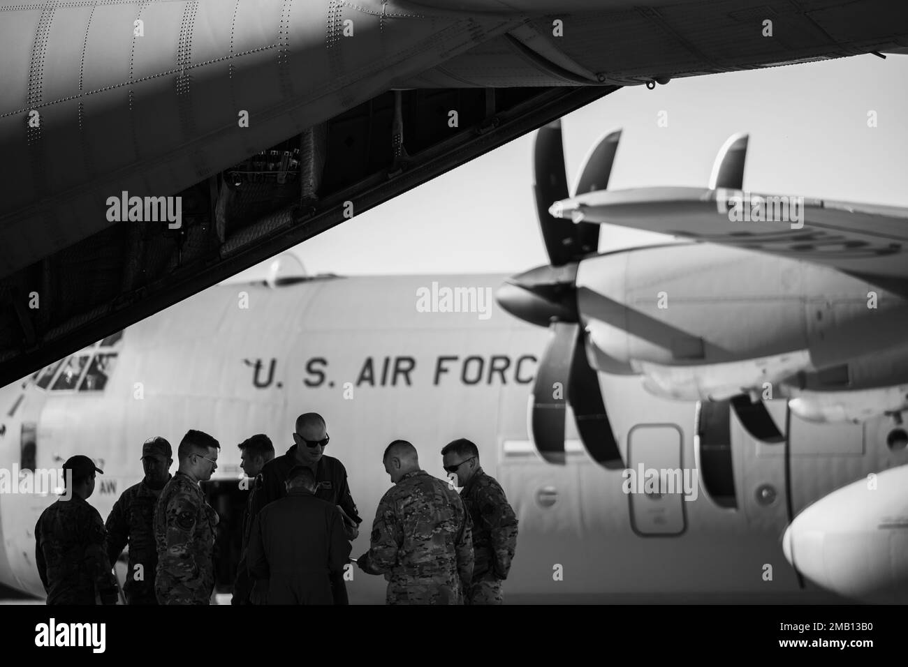 U.S. Air Force Airmen hold a mission brief behind a C-130H Hercules aircraft from 169th Airlift Squadron, Peoria Air National Guard Base, Peoria, Illinois, during Agile Rage 22 at Alpena Combat Readiness Training Center in Alpena, Mich., June 9, 2022. Agile Rage 22 is a National Guard Bureau-led exercise that provides realistic training opportunities, mimicking current and future combat environments dictated by the National Defense Strategy. Stock Photo