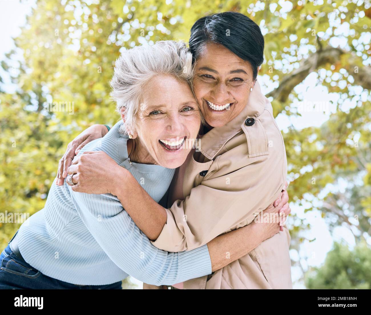 Senior women, portrait and laughing hug in nature park, garden or relax environment in retirement, support or trust. Smile, happy friends and bonding Stock Photo