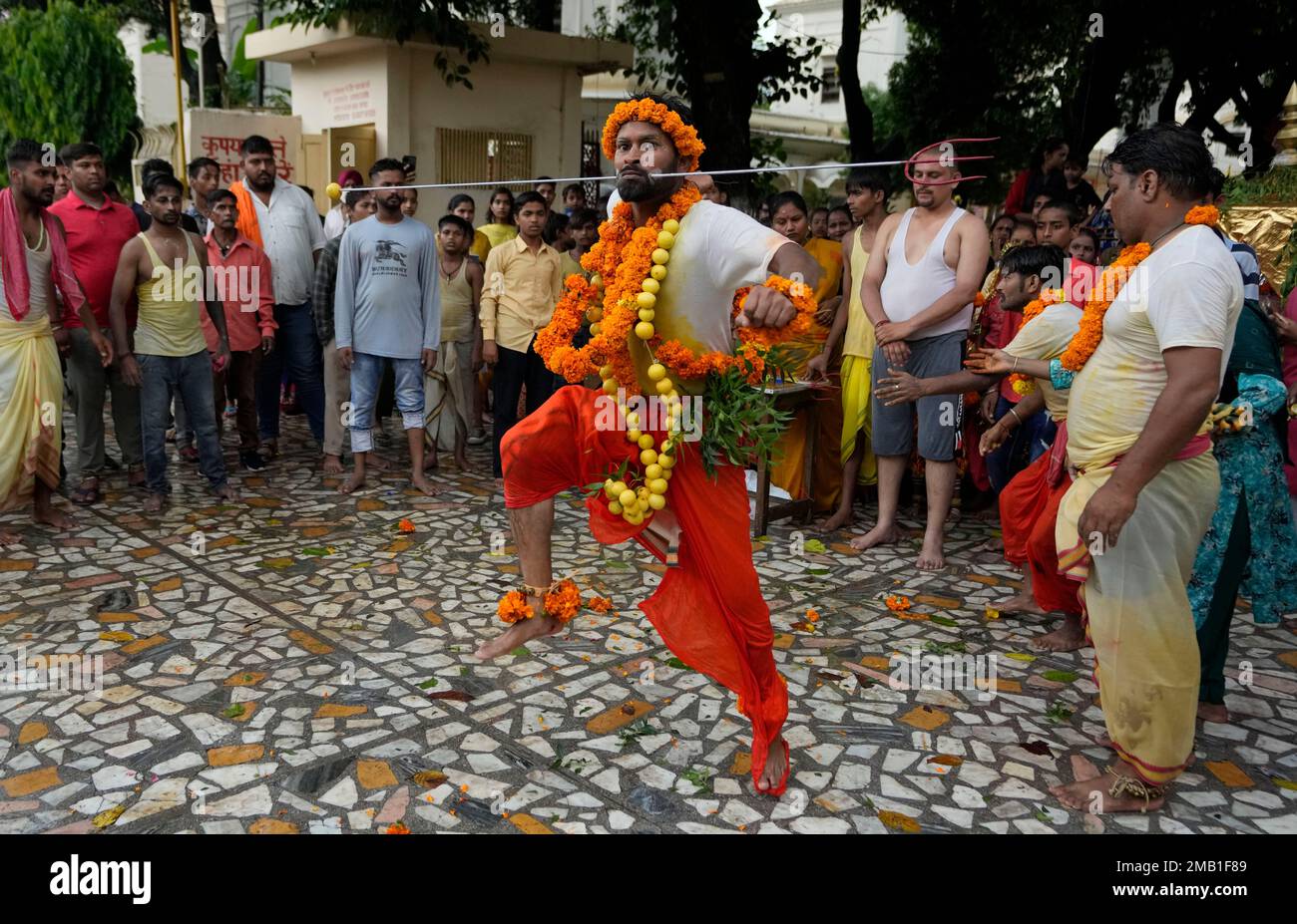 An Indian Hindu devotee dances after piercing a steel rod through his ...