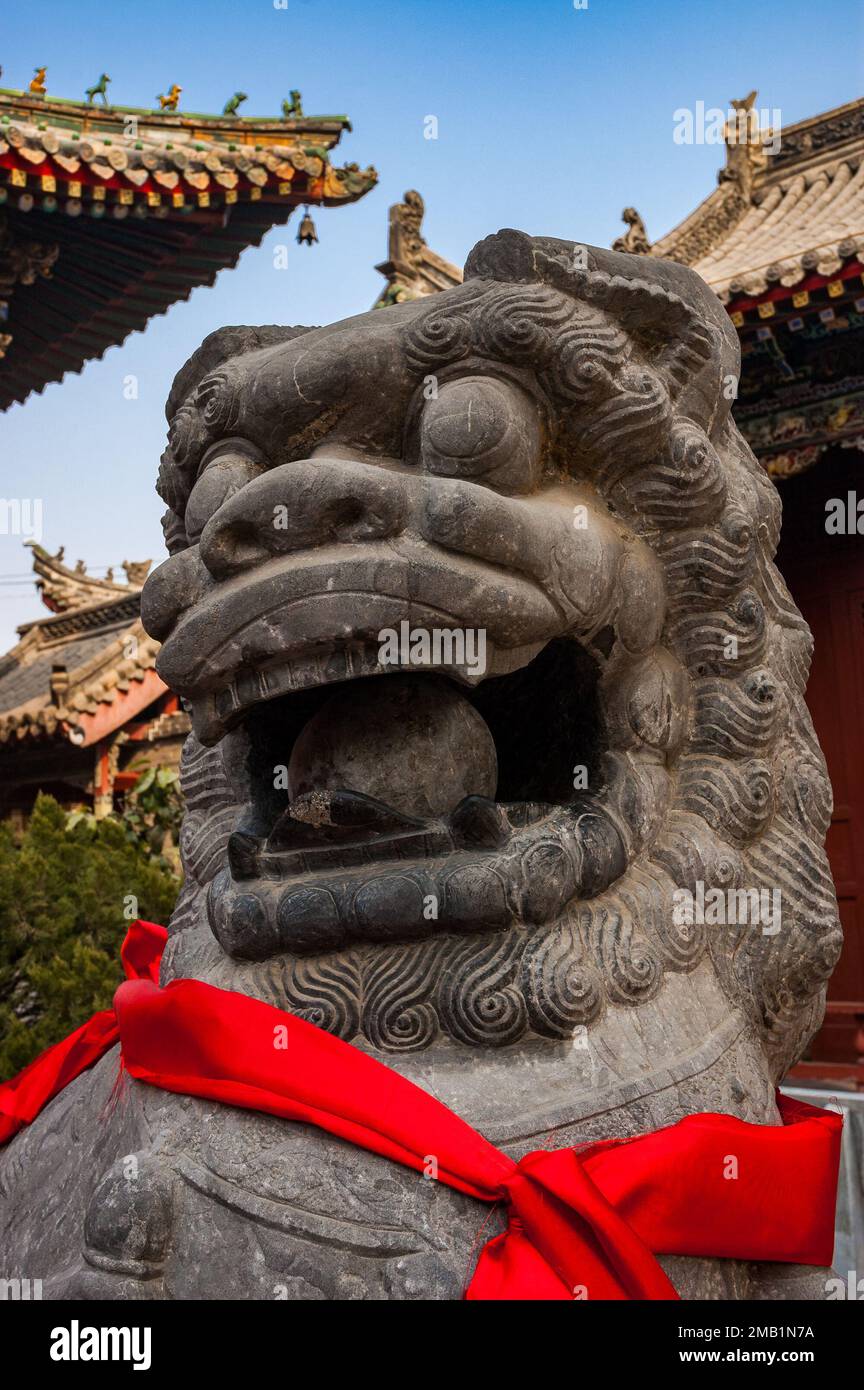 Stone lion in front of buildings at the Shanshangan guild hall in Kaifeng. Kaifeng was the capital of the Northern Song Dynasty. Henan Province, China Stock Photo