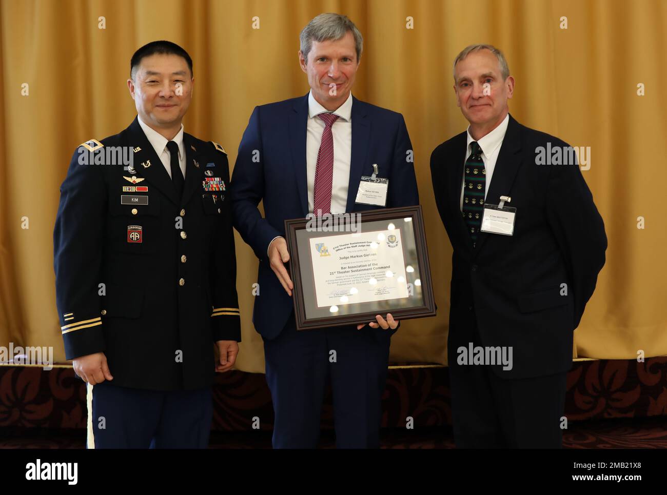 Col. Tony Kim, Staff Judge Advocate for the 21st Theater Sustainment Command (Left), Judge Markus Gietzen, member of the Bar Association of the 21st TSC (Middle), and  Peter Masterton, Chief of International Law Division and Senior Civilian Advisor, 21st TSC (Right), pose for photo displaying plaque given to Gietzen, June 10, 2022, at the Armstrong Club, Vogelweh, Germany. The Law Day event offers excellent opportunities for personal and professional exchanges between local U.S. Armed Forces members and the Rhineland-Palatinate judiciary members. Stock Photo