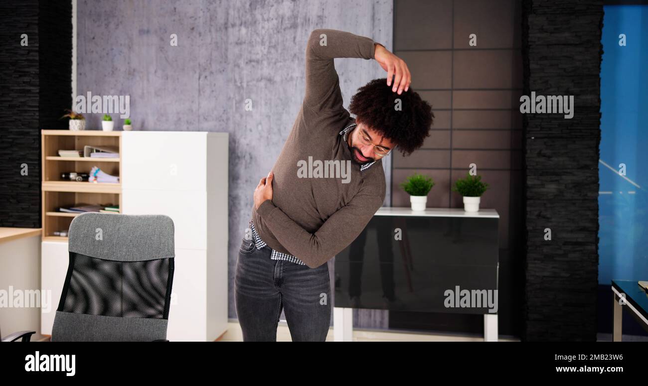 African American Male Exercise Office. Stretching Workout Stock Photo