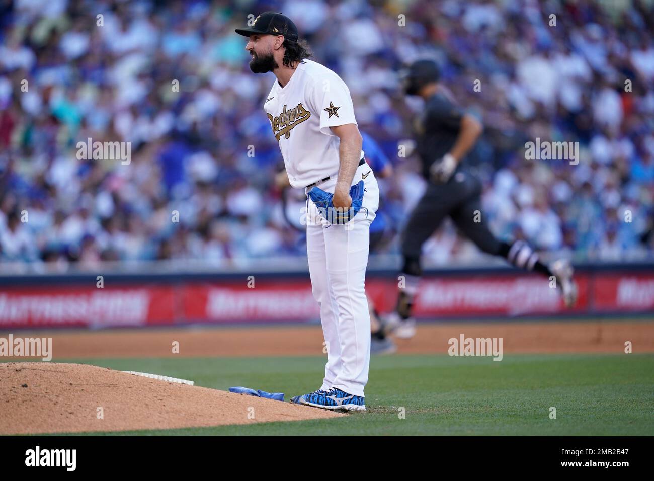 National League relief pitcher Tony Gonsolin, of the Los Angeles Dodgers,  walks off the mound after giving up a two run home run to American League  Giancarlo Stanton, of the New York