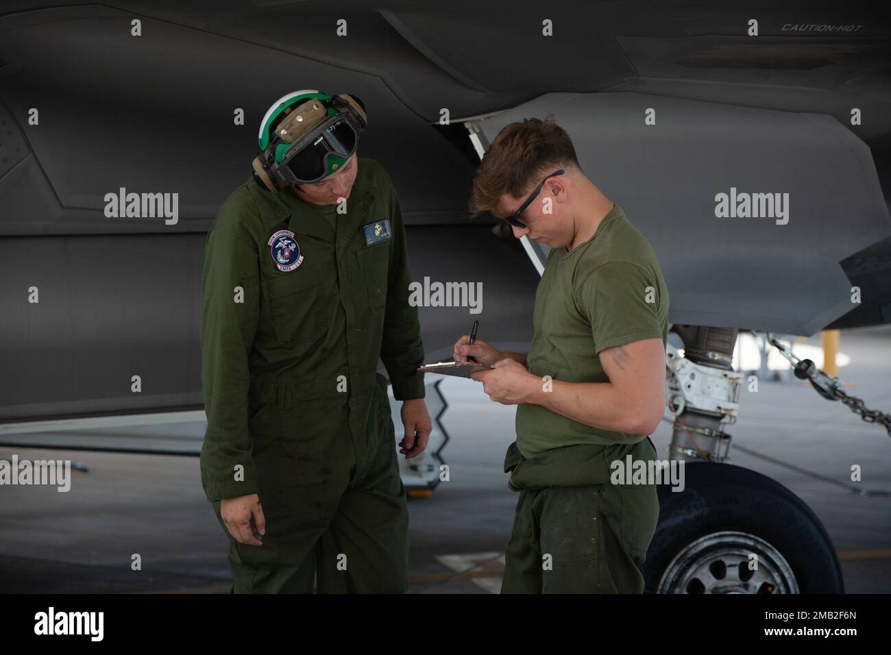 U.S. Marine Corps Lance Cpl. Logan Runnells, left, and Cpl. Jaden Johnson, both fixed-wing aircraft mechanics with Marine Fighter Attack Squadron (VMFA) 122, 13th Marine Expeditionary Unit, review a maintenance check list during Realistic Urban Training exercise at Marine Corps Air Station Yuma, Arizona, June 9, 2022. The purpose of RUT is to enhance the integration and collective capability of the MEU's command, air, ground, and logistics elements and prepare the 13th MEU to meet the nation's crisis response needs during its upcoming overseas deployment. Stock Photo