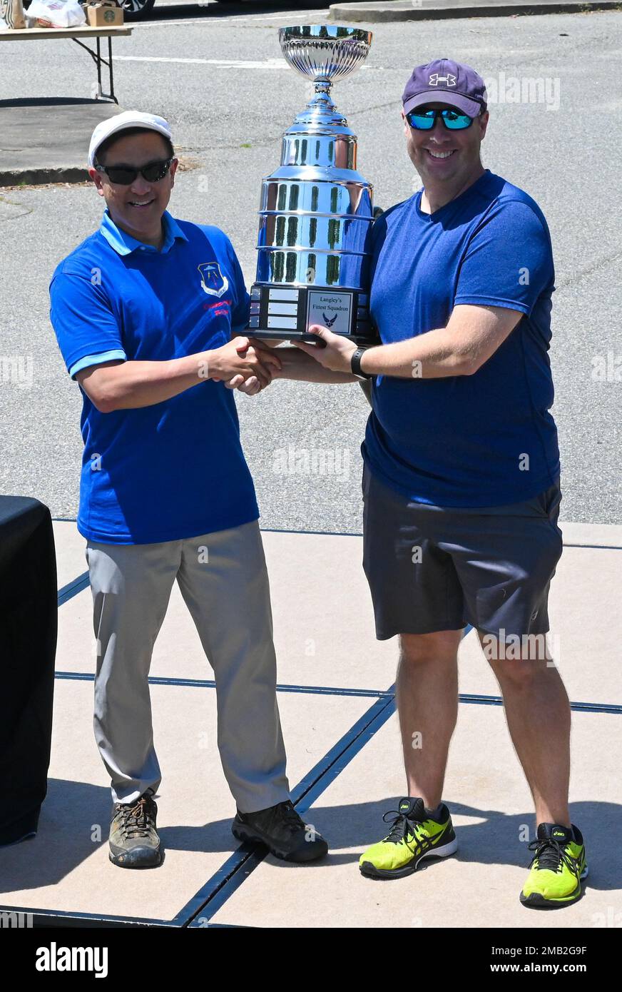 U.S. Army Col. Harry Hung, 633d Air Base Wing vice commander, left, and a  U.S. Airman from the 36th Intelligence Squadron, right, holds the first  place trophy during the Crossbow Games at