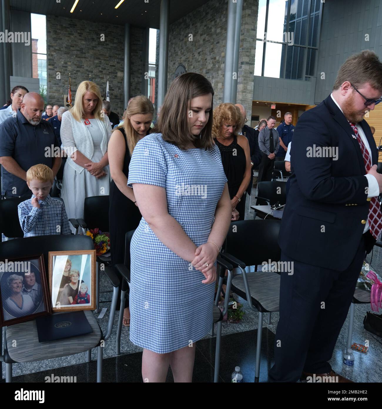 Members of the Bushey family and guest attendees bow their heads during