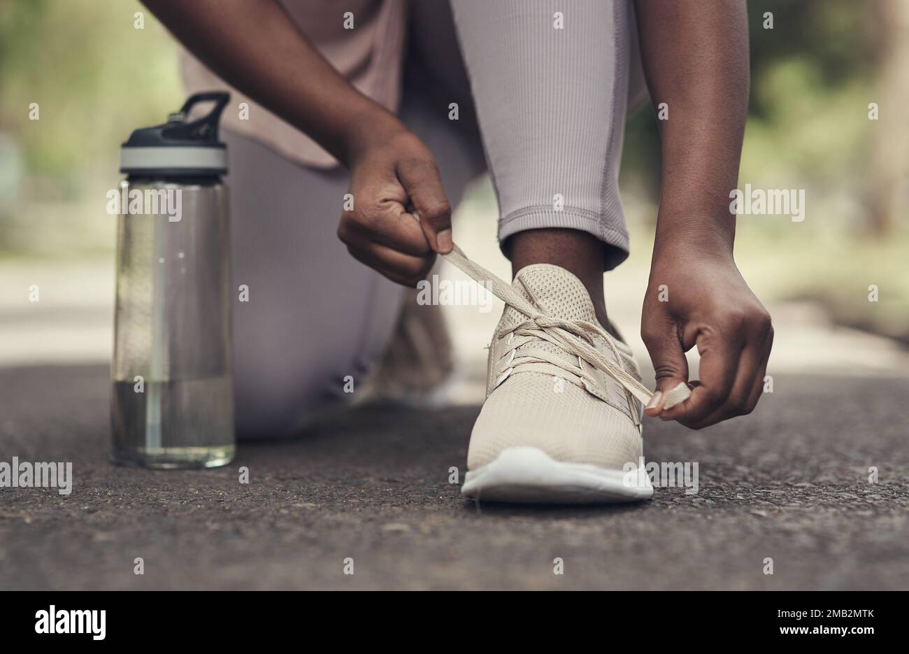 Lacing up to run the race. a woman tying her shoes before working out. Stock Photo