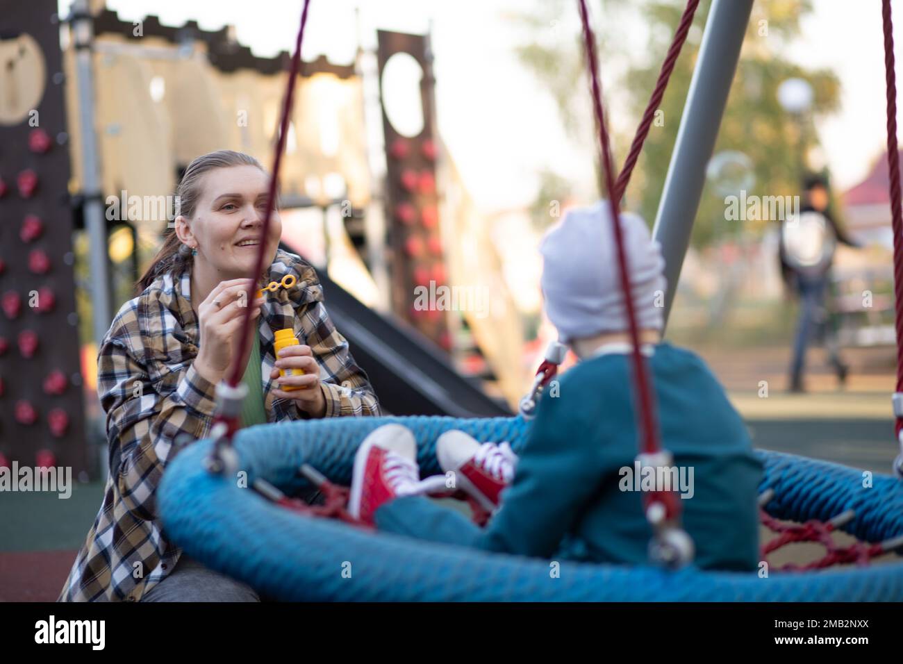 A boy, person with down syndrome walks in the park with his mother