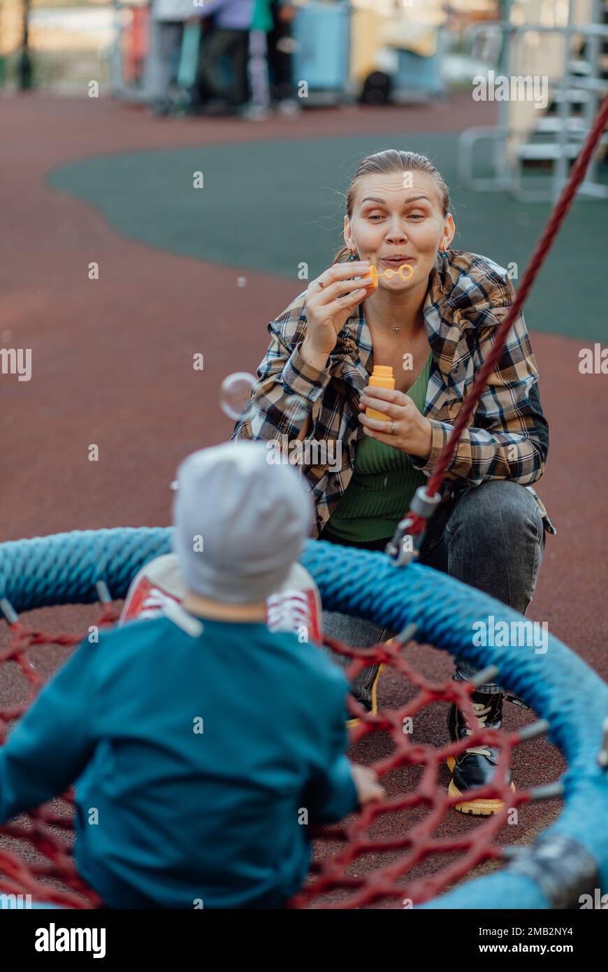 A boy, person with down syndrome walks in the park with his mother