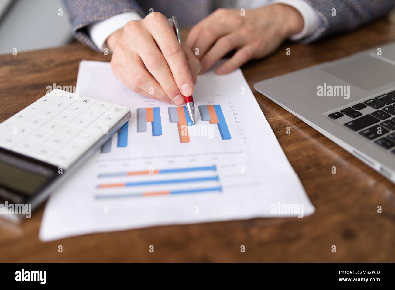 business graph on paper close up on desk in office with laptop and  calculator Stock Photo - Alamy