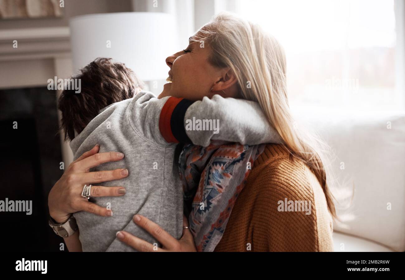 Mother, sofa and boy child with hug, love and comfort in happy care in home living room. Happy family together, couch and kid with mama, embrace and Stock Photo
