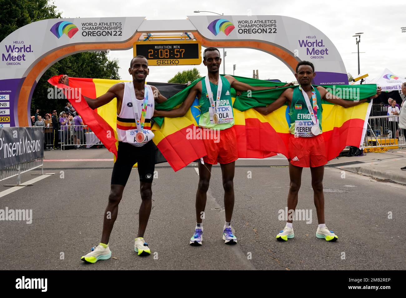 Gold medalist Tamirat Tola, of Ethiopia, center, stands with silver ...