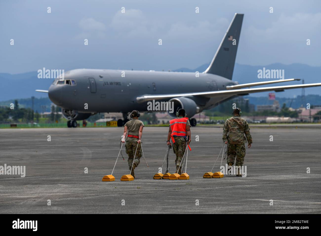 374th Aircraft Maintenance Squadron Airmen drag chocks across an