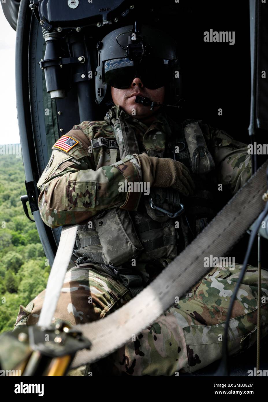 Staff Sgt. Nicholas Metheny, Loadmaster for the Medical Evacuation Crew from G Company 3-238th General Support Aviation Battalion, oversees Fort Chaffee from the air in a routine orientation flight.  Metheny and his crew support Arkansas National Guard units participating in annual training by checking units' locations, training areas, firing ranges, and for potentially hazardous areas; the information gathered is then cross-referenced with their area maps. By conducting these daily flights, the crew can stay prepared to aid during natural disasters or instances where individuals are injured i Stock Photo