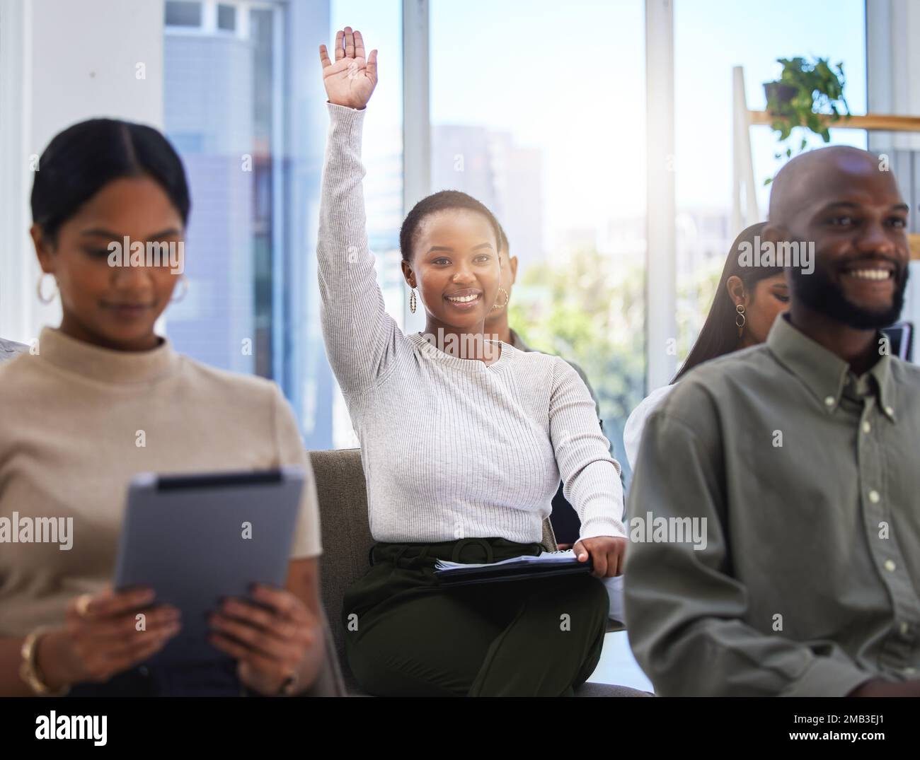 Woman raising hand in meeting hi-res stock photography and images - Alamy