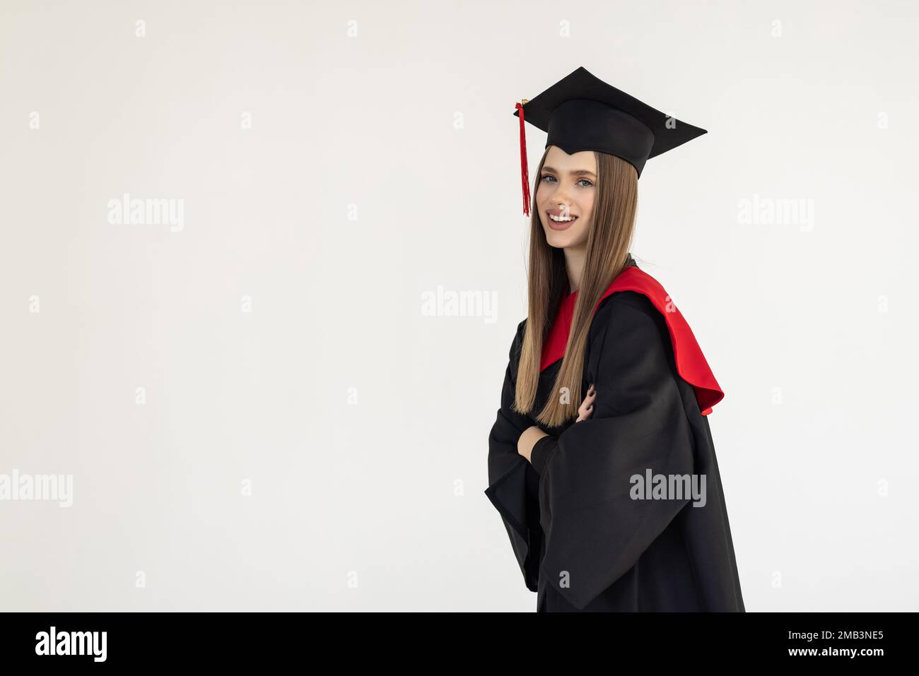 Graduate girl with master degree in black graduation robe and cap on