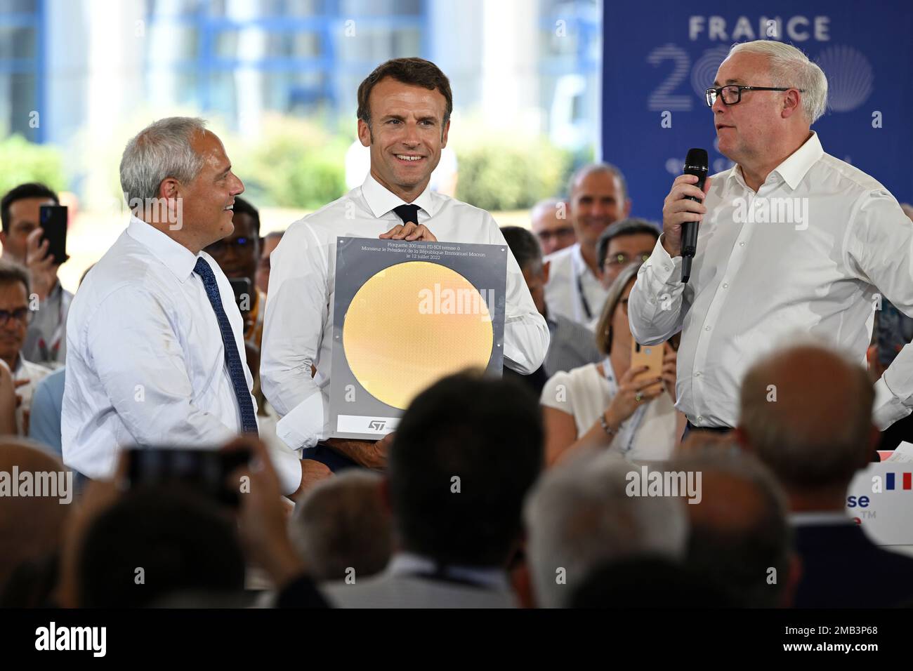 France's President Emmanuel Macron, center, flanked by Global Foundries  chairman Thomas Caulfield , left, listens to the speech of STM chairman Jean -Marc Chery during his visit to the STMicroelectronics (STM) company in