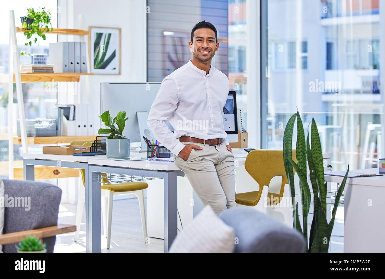 He has a strong drive to succeed and to overcome obstacles. a young businessman standing in a modern office. Stock Photo