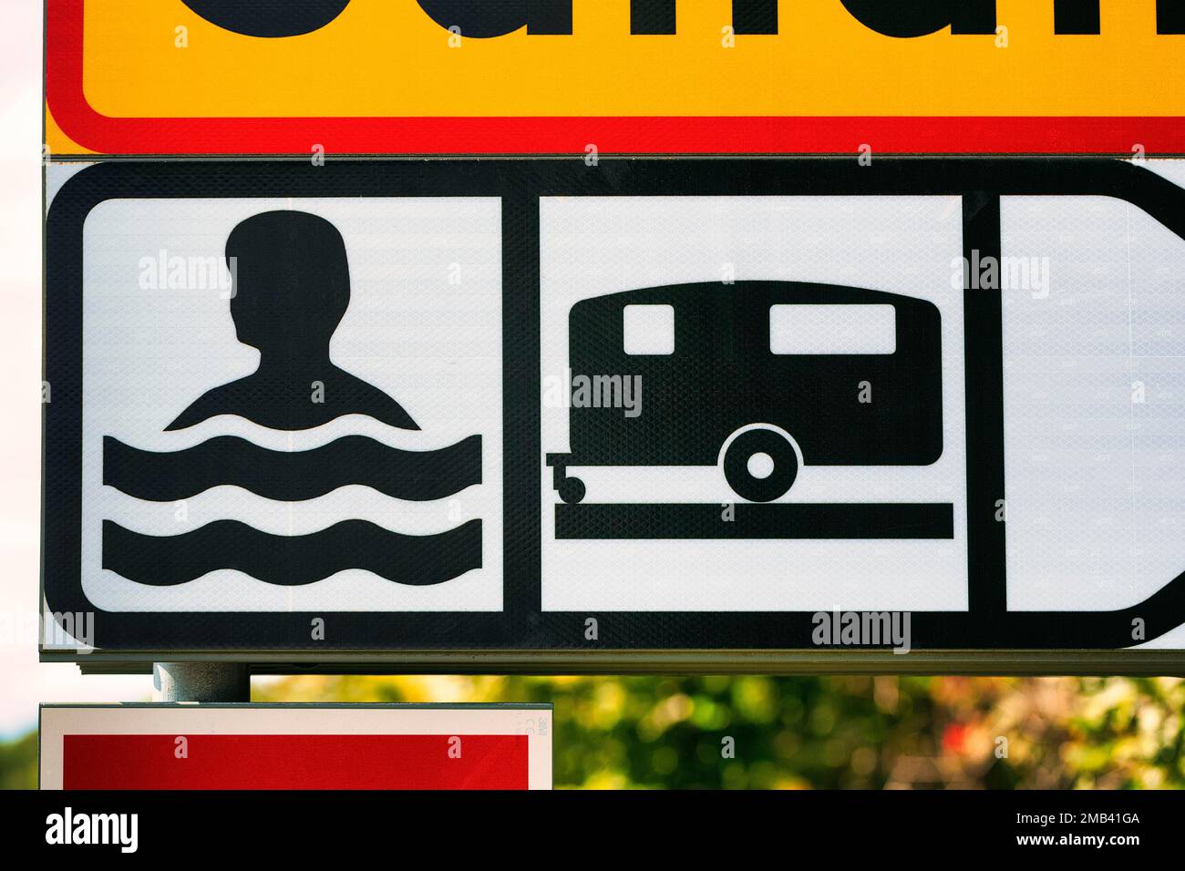 Sign, bathing place by the sea and camping site, with pictogram swimmer and caravan, Gotland Island, Sweden Stock Photo