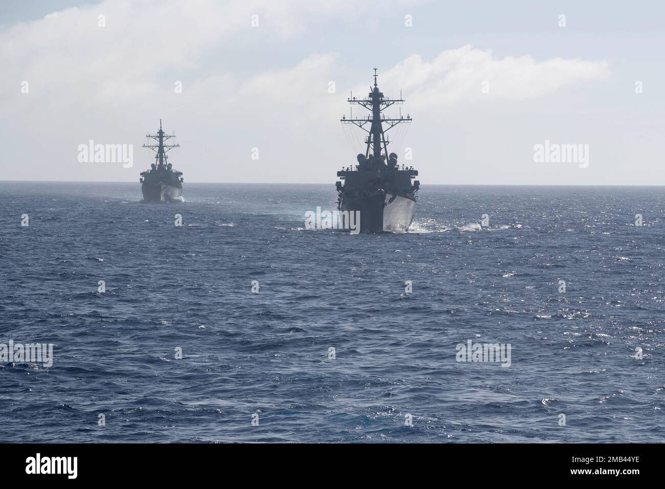 220612-N-XN177-1252 (PHILIPPINE SEA) – Arleigh Burke-class guided-missile destroyers USS Benfold (DDG 65), right, and USS Fitzgerald (DDG 62) steam behind amphibious assault carrier USS Tripoli (LHA 7) during a photo exercise for Valiant Shield 2022, June 12, 2022. Exercises like VS22 allow forces across the Indo-Pacific the opportunity to integrate Navy, Marine Corps, Army, Air Force and Space Force to train in precise, lethal, and overwhelming multi-axis, multi-domain effects that demonstrate the strength and versatility of the Joint Force. Tripoli is operating in the U.S. 7th Fleet area of Stock Photo