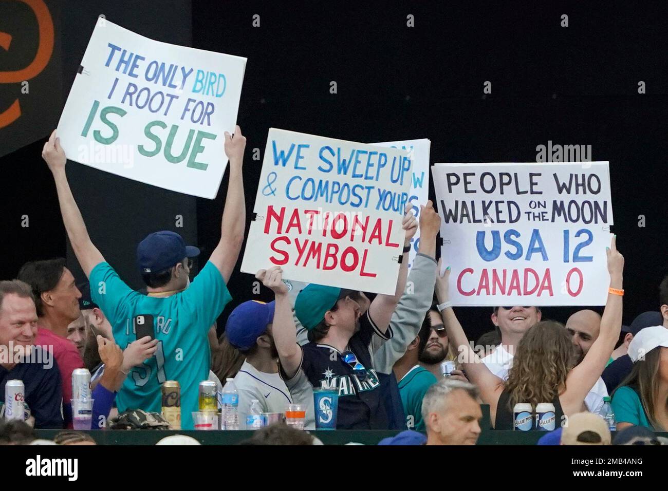 Seattle Mariners fans hold up signs mocking Canada during a baseball game  between the Mariners and the Toronto Blue Jays, Friday, July 8, 2022, in  Seattle. The sign on the left refers