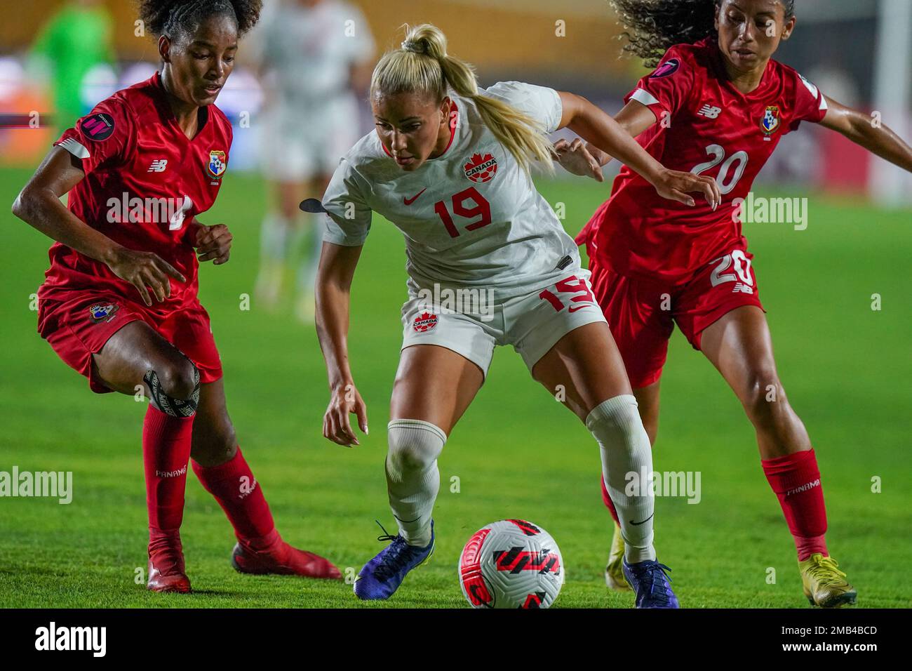 Canada's Adriana Leon, center, fights for the ball against Panama's