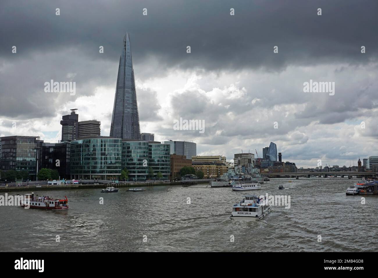 The Shard skyscraper, Thames bank, boat traffic on Thames, dark clouds in the sky, Southwark, London, England, United Kingdom Stock Photo