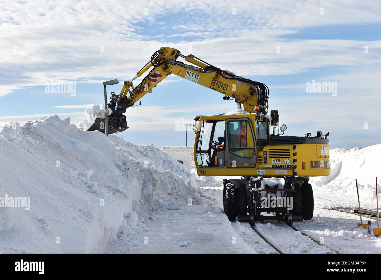 Two-way excavator clears the tracks of the Harz narrow-gauge railway from snow on the Brocken, Saxony-Anhalt, Germany Stock Photo