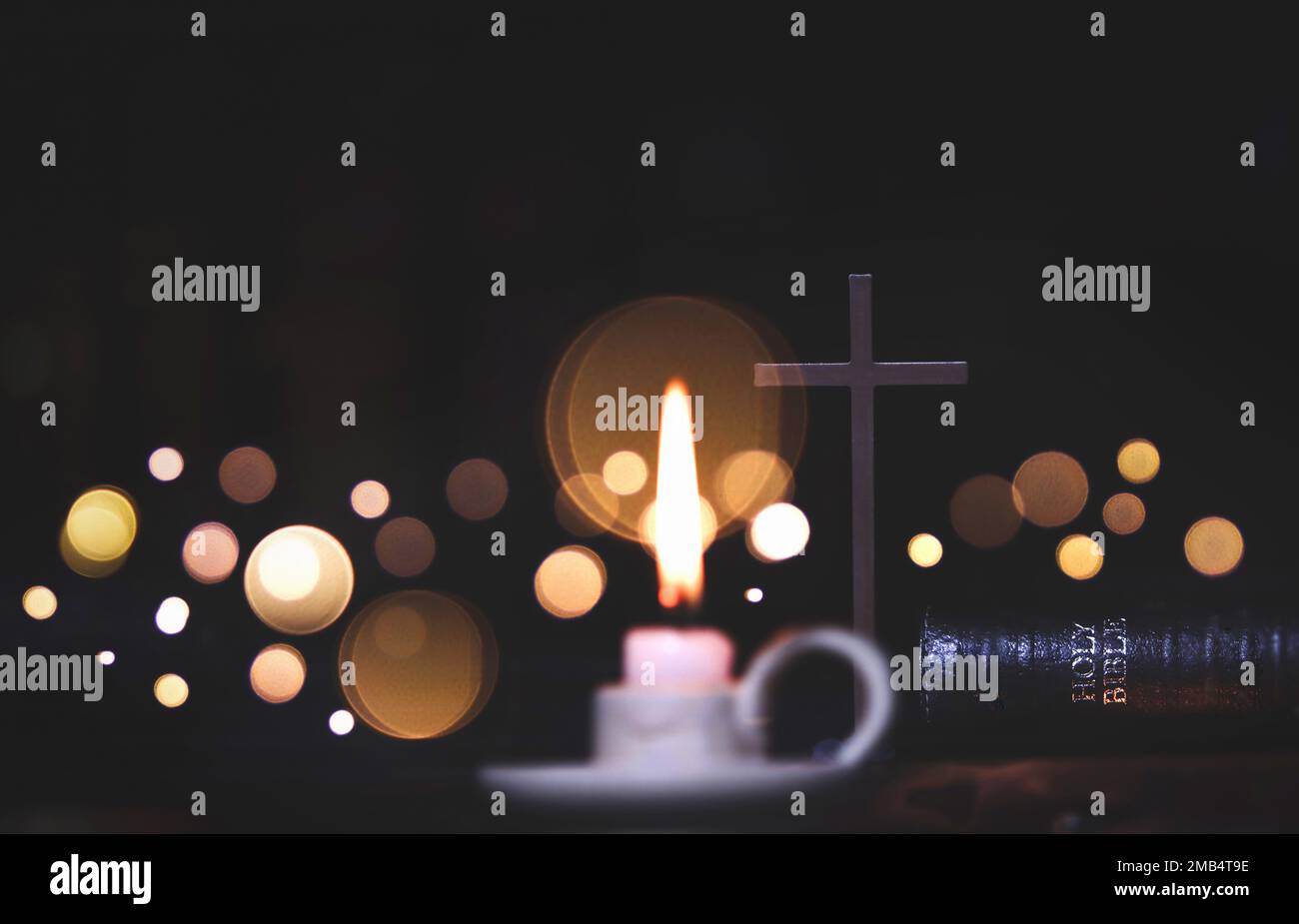Candlestick and candle and holy cross and bible and light background Stock Photo